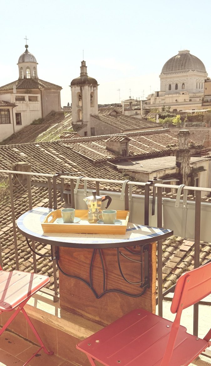 Morning coffee on the mosaic balcony table, with the dome of the Great Synagogue beyond the rooftops