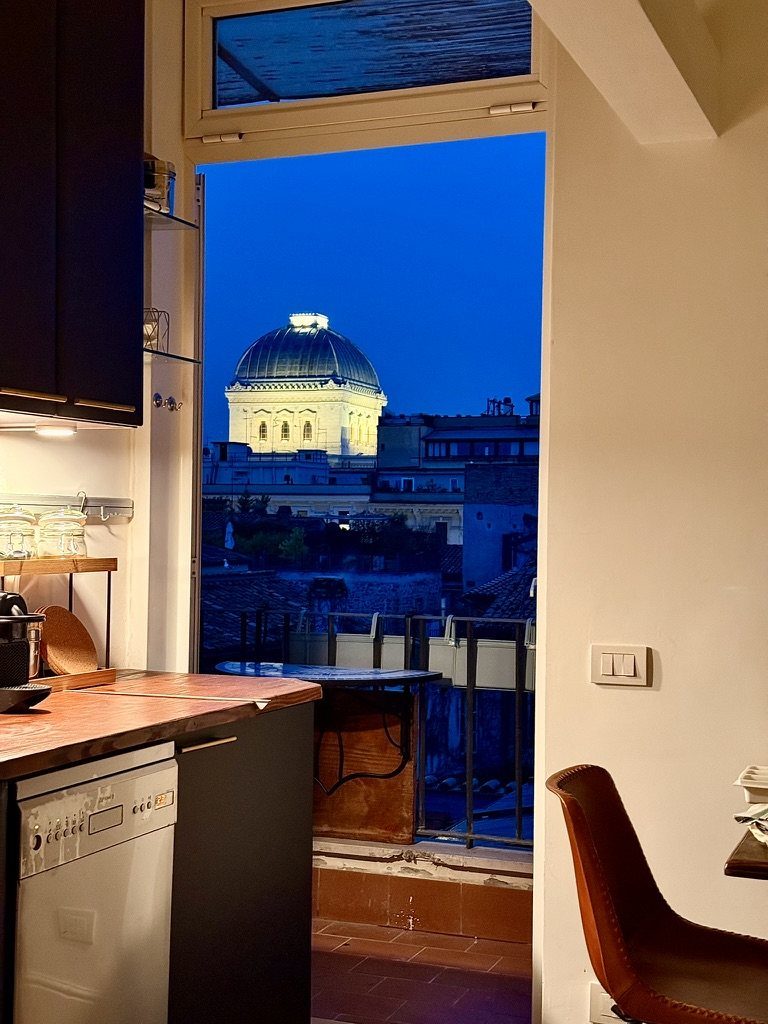 The dome of the Great Synagogue, lit up at night, seen through the balcony door from the kitchenette