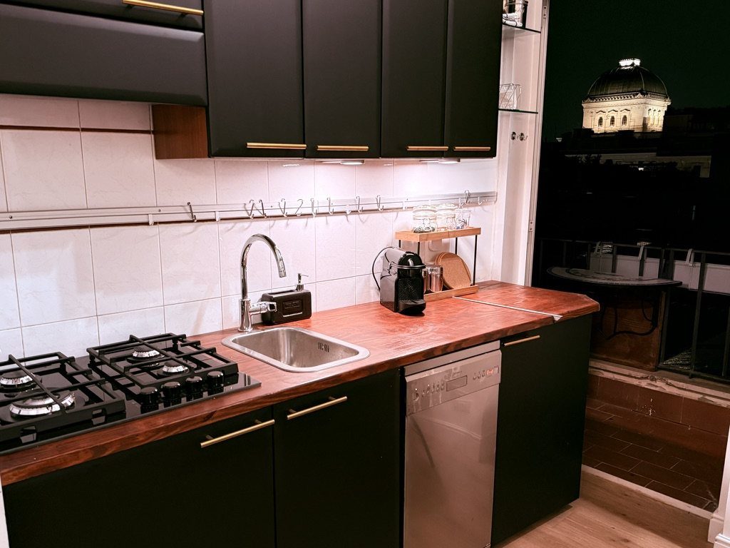The kitchenette at night, with the balcony and the lit dome of the Great Synagogue beyond