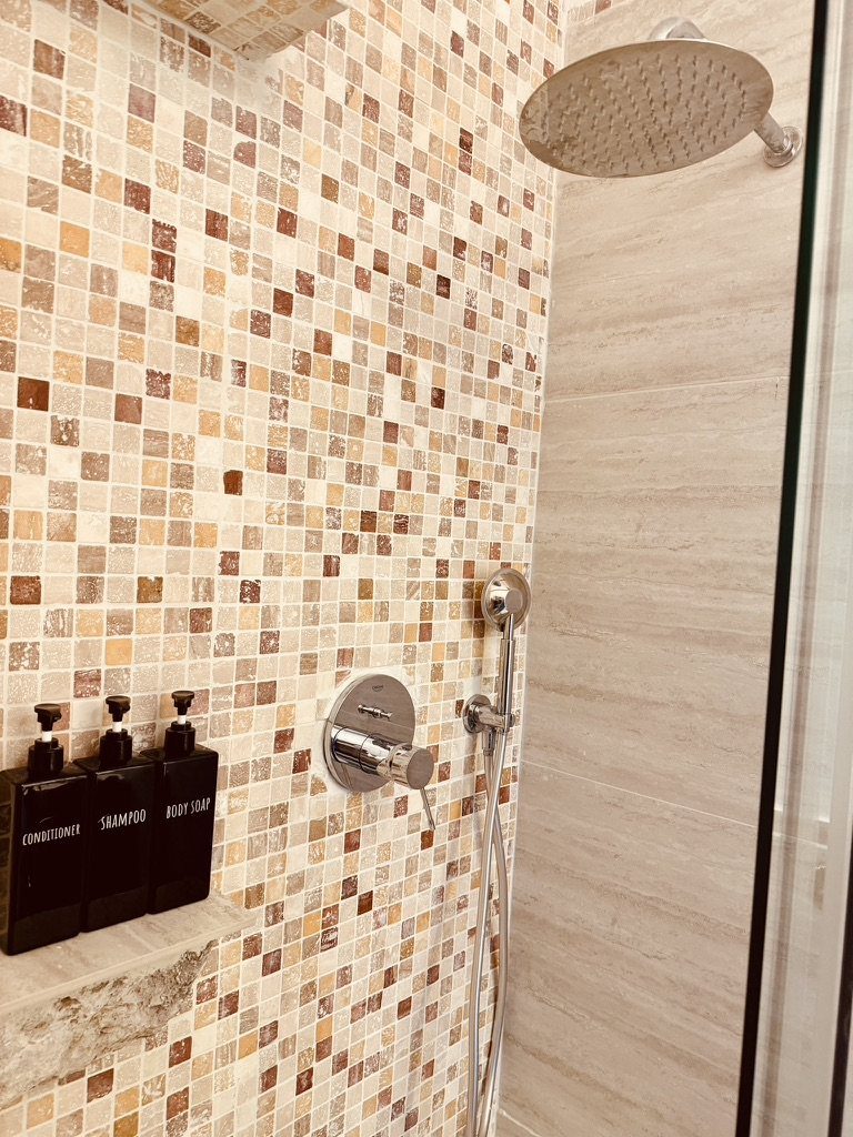 The shower, with a rain showerhead and shampoo, conditioner and body soap provided