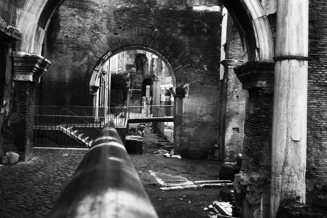 Black-and-white view through the ancient arches of the Portico d’Ottavia