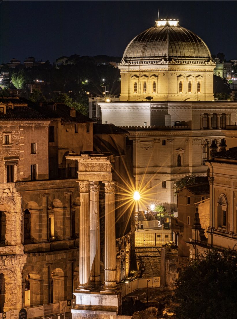 The Great Synagogue of Rome at night, behind the columns of an ancient temple